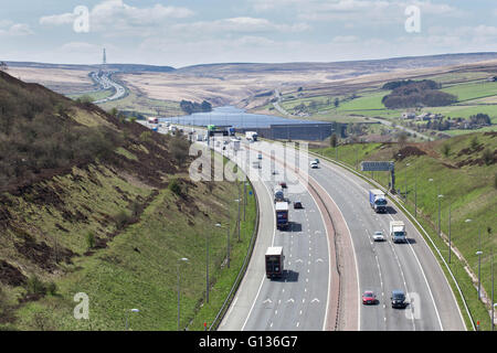 Il traffico passa Booth serbatoio di legno sull'autostrada M62, in una giornata di sole, vicino a Huddersfield, nello Yorkshire, Inghilterra, il 4 maggio 2016 Foto Stock