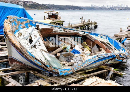 Abbandonato weathered vecchia barca da pesca giacente su un molo in legno vicino Beykoz in Istanbul Foto Stock