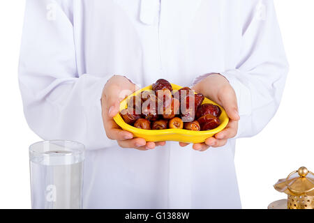 Piccolo ragazzo musulmano presentando un piatto di date per l'Iftar - rottura veloce nel Santo Ramadan Foto Stock