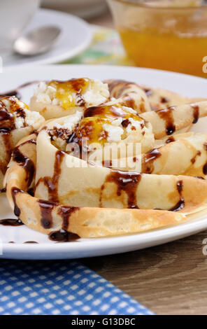 Pancake piegato nella forma di una lumaca per la ricotta con il cioccolato Foto Stock