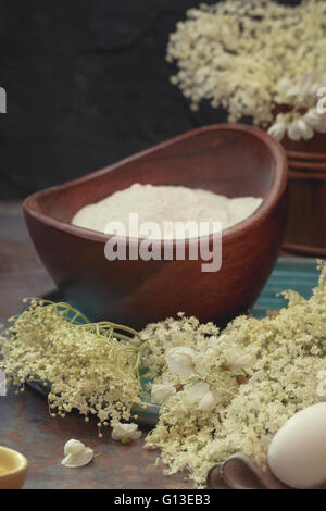 Acacia e fiori di sambuco frittelle preparazione. Macro, il fuoco selettivo vintage immagine dai toni Foto Stock