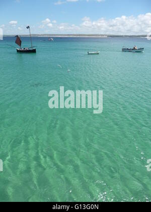 Acque cristalline in St.Ives bay, Cornwall, con numerose piccole imbarcazioni ormeggiate nella baia Foto Stock