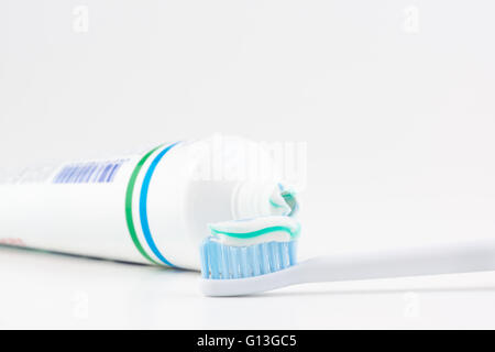 Tubo di dentifricio con una piccola quantità di dentifricio sullo spazzolino Foto Stock