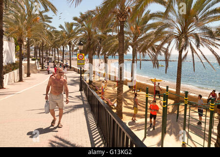 Persone che camminano sulla passeggiata di Marbella ( Paseo Maritimo, Marbella ), Costa del Sol, Andalusia, Spagna Foto Stock