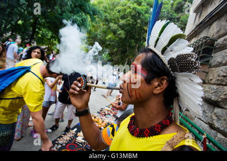 Brasiliano tradizionale indiano con faccia dipinta fumare la pipa al Parque Laje nel comemoration dell'indiano del giorno, Rio de Janeiro, Brasile Foto Stock