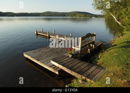 Jetty e panca su un lago in Western Vermont, USA, nella parte anteriore di una cabina di vacanza Foto Stock