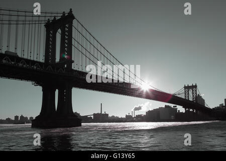 Distorta visione industriale di Manhattan Bridge waterfront New York City a sunrise. Il vapore proveniente da una stazione di alimentazione di Brooklyn Foto Stock