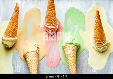 Colorato coni gelato di diversi sapori. I convogliatori di fusione. Vista superiore, acciaio sfondo in metallo Foto Stock