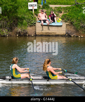 Spettatori godere di sole primaverile come una squadra attraversa la linea del traguardo in occasione dell'annuale Shrewsbury regata sul fiume Severn nello Shropshire, Inghilterra, Regno Unito. Foto Stock