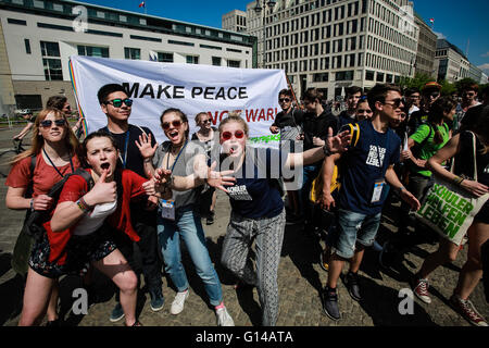 Berlino, Germania. 8 Maggio, 2016. Yound persone pongono per le foto di fronte un banner dicendo 'Make la pace e non la guerra ' vicino alla Porta di Brandeburgo a Berlino, Germania, il 8 maggio 2016. Persone nella capitale tedesca di Berlino si sono riuniti domenica per contrassegnare il 71esimo anniversario della fine della Seconda Guerra Mondiale. © Zhang ventola/Xinhua/Alamy Live News