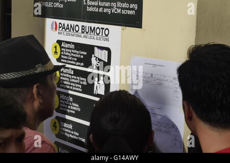 Mandaluyong, Filippine. 09 Maggio, 2016. Gli elettori di controllare la mappa per la loro ubicazione del distretto in cui si voterà. Accanto ad esso è istruzioni passo-passo su come votare. © George Buid/Pacific Press/Alamy Live News Foto Stock