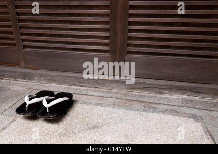 Giapponese in legno scarpe tradizionali di fronte all ingresso di casa Foto Stock