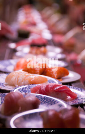 Kaiten sushi con piastre sul nastro in movimento Foto Stock