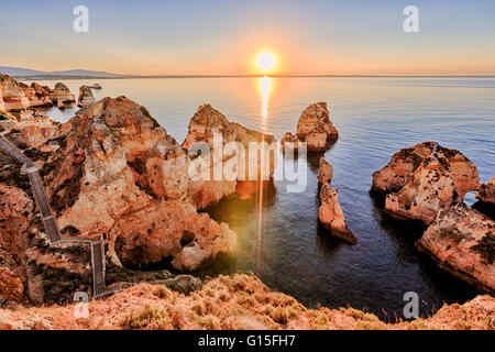 Golden sunrise sulle rocce rosse di Ponta da Piedade, Lagos, Algarve, Portogallo, Europa Foto Stock