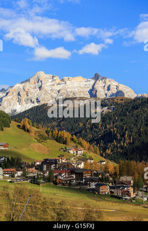 Boschi colorati telaio il villaggio e le cime più alte in autunno, in Val Gardena, Alto Adige, Trentino Alto Adige, Italia, Europa Foto Stock