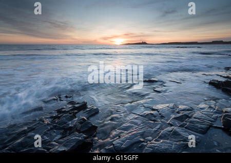 Il castello di Dunstanburgh presso sunrise, visto da di Embleton Bay, Northumberland, England, Regno Unito, Europa Foto Stock