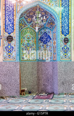 Mihrab è una nicchia semicircolare nella parete di una moschea che indica la qibla; che è la direzione della Kaaba della Mecca e quindi la direzione che i musulmani devono affrontare quando pregando. Si tratta di una sala di preghiera in Hamadan, Iran. Foto Stock