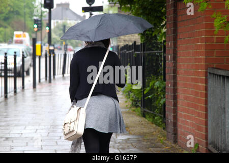 Londra, Regno Unito. Il 10 maggio 2016. Una donna con un ombrello in un giorno di pioggia nel nord di Londra. Credito: Dinendra Haria/Alamy Live News Foto Stock