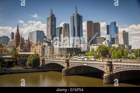 Principi sopra il ponte sul fiume Yarra che conduce alla stazione di Flinders Street con lo skyline di Melbourne Foto Stock