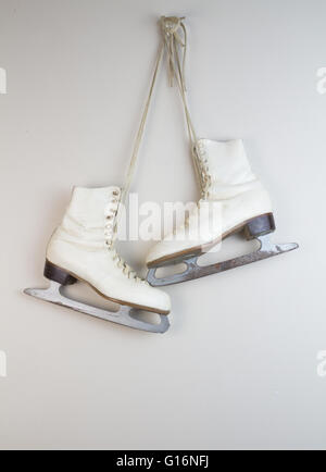 Bianco vecchi pattini da ghiaccio appeso alla parete Foto Stock