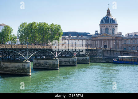 Pedoni sul Pont des Arts Parigi, ringhiere coperte di lucchetti. Istituto de France in background. Foto Stock