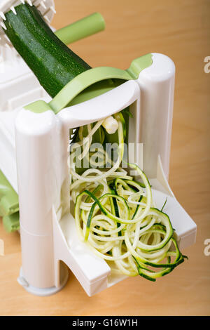 Rendendo la zucchina (zucchine) tagliatelle (spaghetti) con un spiralizer Foto Stock