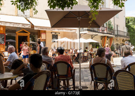 I villeggianti rilassante in un cafe' sul marciapiede, Lourmarin, Luberon, Vaucluse, Provence-Alpes-Côte d'Azur, in Francia Foto Stock