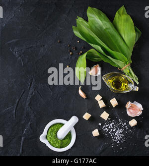 Ingredienti per il pesto e pesto di ramson in mortaio di ceramica. Mazzetto di ramson, olio d'oliva, Parmigiano grattugiato, aglio, sale e pepe o Foto Stock