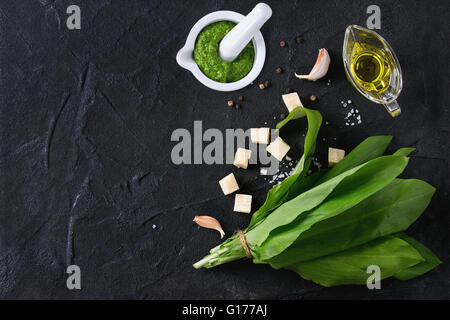 Ingredienti per il pesto e pesto di ramson in mortaio di ceramica. Mazzetto di ramson, olio d'oliva, Parmigiano grattugiato, aglio, sale e pepe o Foto Stock