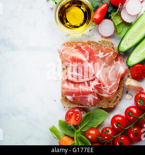 Fetta di pane integrale e una sana verdura biologica per la realizzazione di sandwich. Mangiare sano o il concetto di cucina a vista. Sfondo Foto Stock