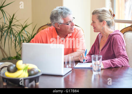 Coppia senior utilizzando laptop e chat a scrivania Foto Stock