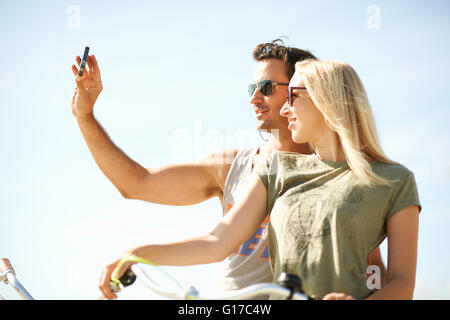 Escursioni in bicicletta giovane prendendo selfie smartphone a Venice Beach, Los Angeles, California, Stati Uniti d'America Foto Stock