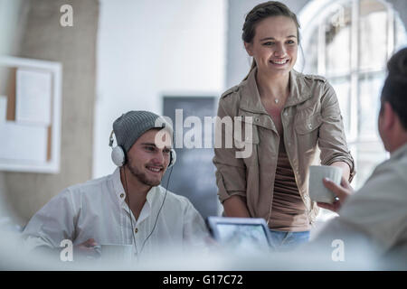 Collega distribuendo del caffè in ufficio loft Foto Stock