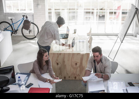 I colleghi avendo discussioni in ufficio loft Foto Stock