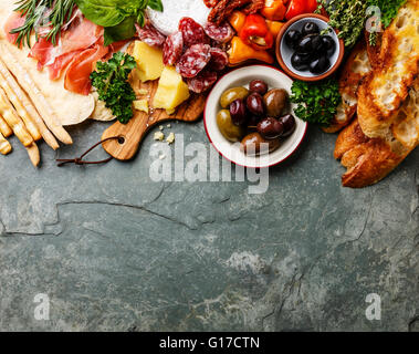 Il cibo italiano ingredienti sfondo con prosciutto, salame, parmigiano, olive, grissini Foto Stock