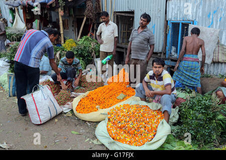 Ghirlande di fiori sono venduti presso il mercato dei fiori sul modo per il Fiume Hooghly al di sotto di quella di Howrah bridge per il culto della divinità del fiume. Calcutta, Calcutta, India Foto Stock