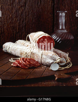 Salsiccia tipo chorizo spagnolo sul tagliere di legno Foto Stock