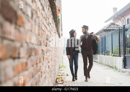 Coppia giovane oltrepassando un muro di mattoni Foto Stock