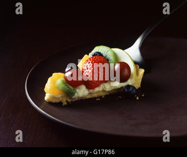 Fetta di fragole, kiwi, arancio e uva tart su piastra Foto Stock