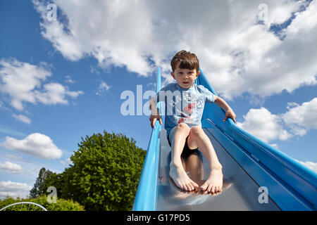 Ragazzo scendendo parco giochi slitta Foto Stock