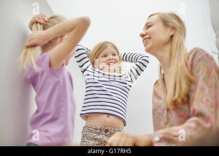 Felice la madre e le figlie seduto sulla scala Foto Stock