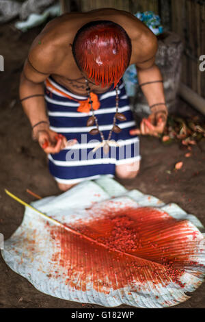 SANTO DOMINGO, ECUADOR - 26 gennaio 2015: uomo indiano Colorados (Los Tsáchila) tribù in vestiti nazionali vernici succo di capelli impianto Foto Stock