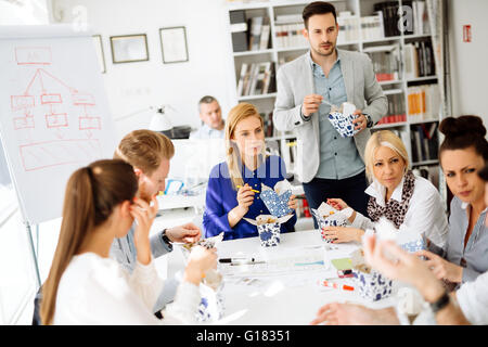 La gente di affari consumare i pasti in ufficio Foto Stock