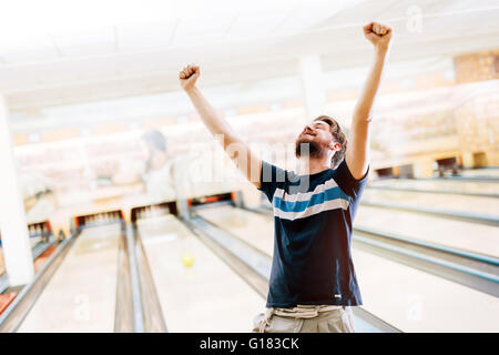 Amici bowling al club e divertirsi giocando casualmente Foto Stock