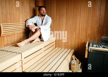 Uomo bello rilassarsi in sauna durante il weekend benessere Foto Stock