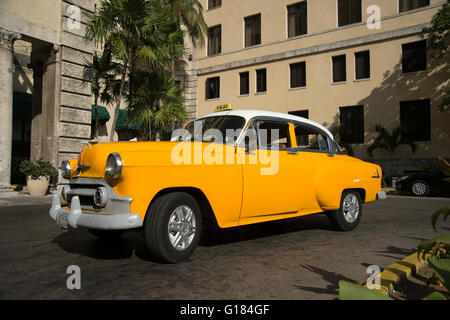 Un vecchio e restaurato 1950's American Automobile usata come un taxi parcheggiato fuori la parte anteriore dell'Hotel Nazionale nel Vedado Avana Cuba Foto Stock