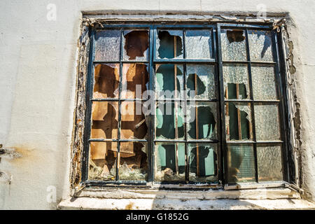 Finestra rotta sul vecchio edificio fracassato vetri derelitti edificio abbandonato Foto Stock