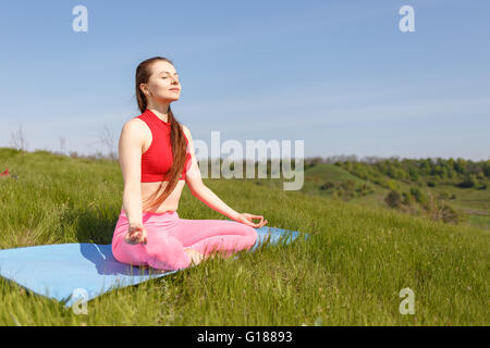 Giovane donna a praticare yoga pone all'aperto. Ragazza facendo una perfetta posa Foto Stock