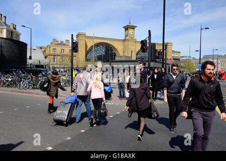 Pendolari strada di attraversamento al di fuori di Kings Cross stazione ferroviaria, Londra Foto Stock