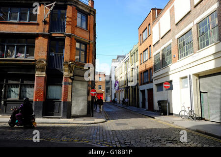 Ciclomotore giostre angolo rotondo su tranquille strade acciottolate nella zona est di Londra Foto Stock